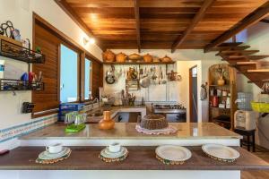 uma cozinha com um balcão com pratos em Recanto de tranquilidade próximo a Morro e Boipeba. Casa espaçosa com piscina a 5 minutos a pé da Praia. em Garapuá