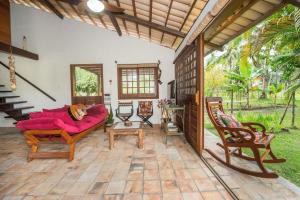 un soggiorno con divano e sedie su un patio di Recanto de tranquilidade próximo a Morro e Boipeba. Casa espaçosa com piscina a 5 minutos a pé da Praia. a Garapuá