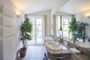 a bathroom with two sinks and two potted plants at ArtVilla am See - offen März bis Ende Oktober in Radolfzell am Bodensee +70 photos