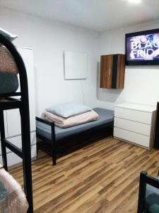 a small room with a bed and a tv at Noclegi Tuszyn S in Tuszyn