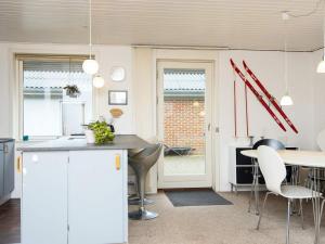 cocina con armarios blancos, mesa y sillas en 6 person holiday home in Hemmet en Hemmet