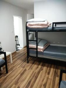 Pokój z 2 łóżkami piętrowymi i drewnianą podłogą w obiekcie Noclegi Tuszyn S w mieście Tuszyn