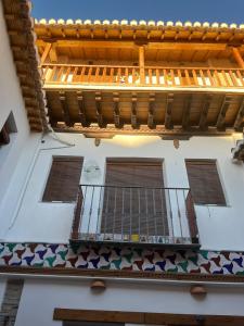 un edificio con balcón y techo de madera en Apartamento patio de los leones, en Granada