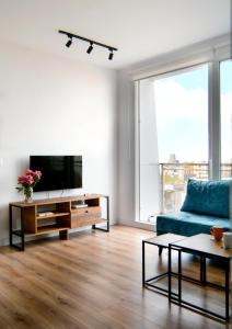 a living room with a blue couch and a tv at Urban Serenity City Skyline View Apartment 1 in Tirana