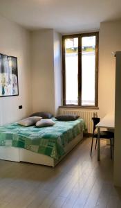 1 dormitorio con 1 cama, 2 ventanas y mesa en Intero Appartamento LGBTQ+ zona Loreto, en Milán