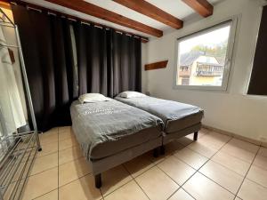 - une chambre avec un lit dans une pièce dotée d'une fenêtre dans l'établissement La parenthèse - Domaine prestige, à Osenbach