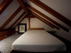 1 dormitorio con 1 cama blanca en el ático en La parenthèse - Domaine prestige, en Osenbach