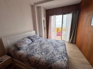 a bedroom with a bed and a large window at Casa Caballito de mar-Seahorse House in Bahía de Caráquez
