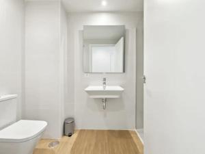 Un baño blanco con lavabo e inodoro. en Denia port and beach apartment., en Denia 22 fotos más