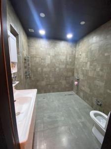 ein Badezimmer mit einem WC, einem Waschbecken und einem Urinal in der Unterkunft Дом in Cǝnubi