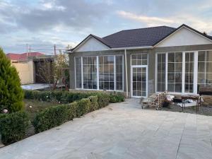 ein Haus mit großen Fenstern und einer Terrasse in der Unterkunft Дом in Cǝnubi