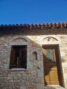 a building with two windows and a door at MELATO HOUSES in Valtessiniko 
