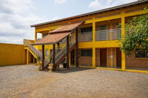 a yellow building with stairs in front of it at Pousada Mota in Bonito