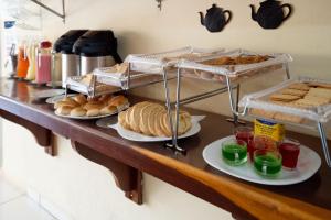 a counter with plates of bread and pastries on it at Pousada Mota in Bonito