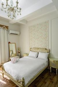 a bedroom with a large white bed with a chandelier at El Otel The Hotel in Cairo