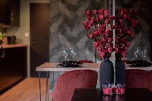 a table with two vases filled with red roses at L'Insoupçonnée in Nantes