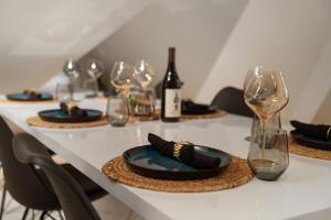een tafel met glazen en borden en wijnflessen bij Arctic Homes - Premium Retreat in Tromsø
