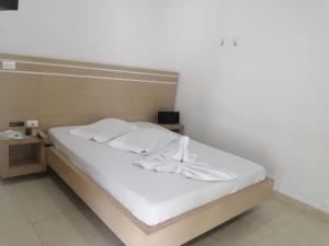 a bed with white sheets and pillows in a room at MOTEL CUPIDO (PALMIRA) in Palmira