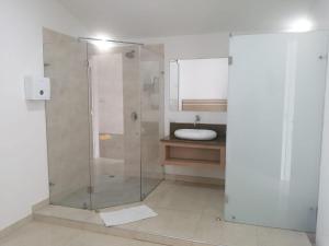a bathroom with a glass shower and a sink at MOTEL CUPIDO (PALMIRA) in Palmira