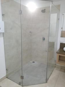 a shower with a glass door in a bathroom at MOTEL CUPIDO (PALMIRA) in Palmira