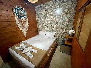 a small room with a bed with towels on it at Balam Holbox in Holbox Island
