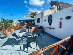 a patio with chairs and a table and umbrella at Balam Holbox in Holbox Island