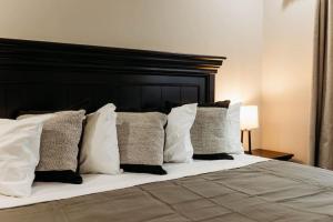 - un lit avec des oreillers blancs et une tête de lit noire dans l'établissement Luxury Cliffside Hammock House, à Wellington