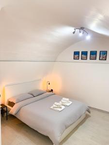 Dormitorio blanco con cama y lámpara en Le Vie del Borgo, en Sannicandro di Bari