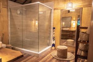 a glass shower in a bathroom with a sink at Mansur Hotelaria de Charme in Luis Correia