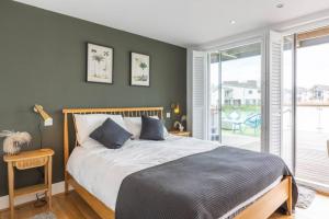 a bedroom with a bed and a large window at Skylark Lodge HM24 HOT TUB Lakeside Spa in Somerford Keynes