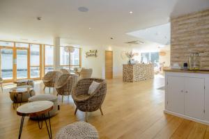 a lobby with chairs and tables and a counter at Tawny House CW6 Lakeside Spa Property in Somerford Keynes