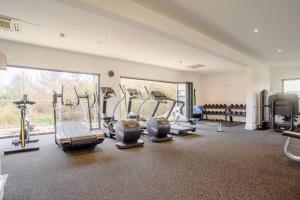 a gym with several treadmills and machines in a room at Tawny House CW6 Lakeside Spa Property in Somerford Keynes