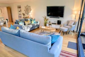a living room with a blue couch and a table at Natures Retreat HM99 HOT TUB Lakeside Spa in Somerford Keynes