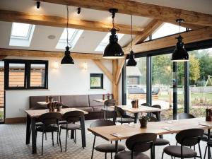 a restaurant with tables and chairs and windows at Pennyroyal Lodge HM31 Lakeside Spa Property in Somerford Keynes