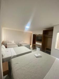a hotel room with two beds and a sink at Serra Plaza Premium in Serrinha