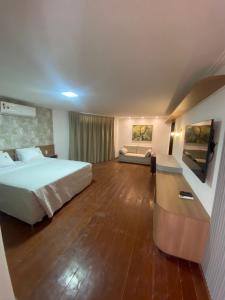 a hotel room with a bed and a couch at Serra Plaza Premium in Serrinha