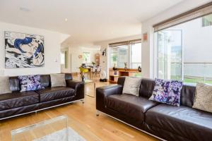 a living room with two brown leather couches at Osprey Lodge CW64 HOT TUB Lakeside Spa Property in Somerford Keynes