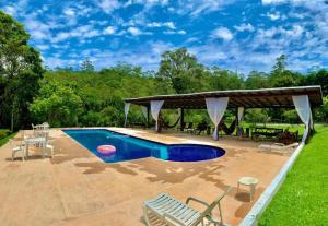 einen Pool mit einem Pavillon und einer Terrasse in der Unterkunft Chalé 3 Descanso nas Nascentes in Salesópolis