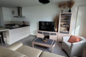 a living room with a couch and a tv and a table at Le Tableau du Lac 507 - 2 bedrooms apartment with lake view terrace in Annecy