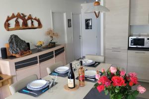 a dining room table with flowers and wine bottles at Le Tableau du Lac 507 - 2 bedrooms apartment with lake view terrace in Annecy