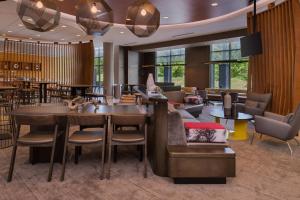 een lobby met tafels en stoelen en een restaurant bij SpringHill Suites Pittsburgh Southside Works in Pittsburgh