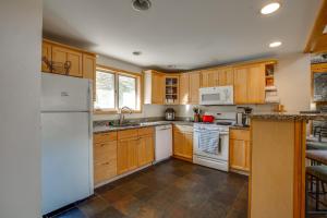 una cocina con armarios de madera y electrodomésticos blancos en Northbrook Condo condo, en Killington
