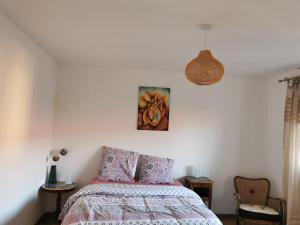 1 dormitorio con 1 cama y una pintura en la pared en Logement Colmar centre avec Parking en Colmar