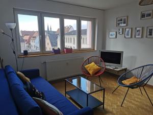 sala de estar con sofá azul y 2 sillas en Logement Colmar centre avec Parking en Colmar