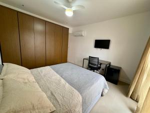 Dormitorio con cama, escritorio y TV en Suite privativa na Barra da Tijuca, RJ - Neolink Stay en Río de Janeiro