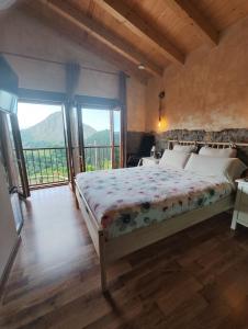 sypialnia z łóżkiem w pokoju z oknami w obiekcie Hotel Granja Paraíso, Oasis Rural & Bienestar w mieście Cangas de Onís