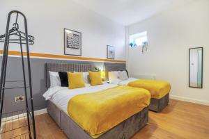 a bedroom with two beds with yellow sheets at Spacious City Centre Apartment - Sleeps 8 in Liverpool