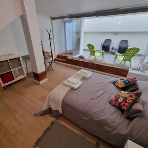 uma cama grande num quarto com cadeiras verdes em Casa Sonho Azores - AL 1449 em Ponta Delgada