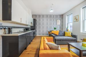 a kitchen and living room with a couch and a table at Spacious City Centre Apartment - Sleeps 8 in Liverpool