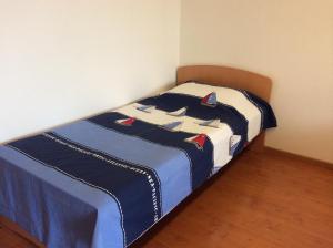 a bed in a room with a blue and white blanket at Apartments Krt Mirko in Izola